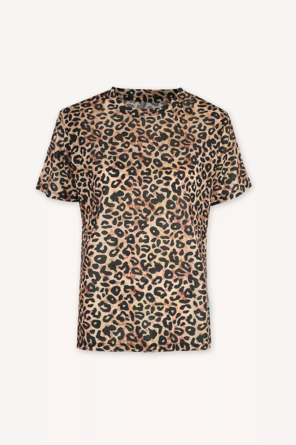 Osoba s krátkými blond vlasy v leopardí košili přes černý rolák z wełny merino 100% stojí venku, oči zavřené, rolák přes ústa.