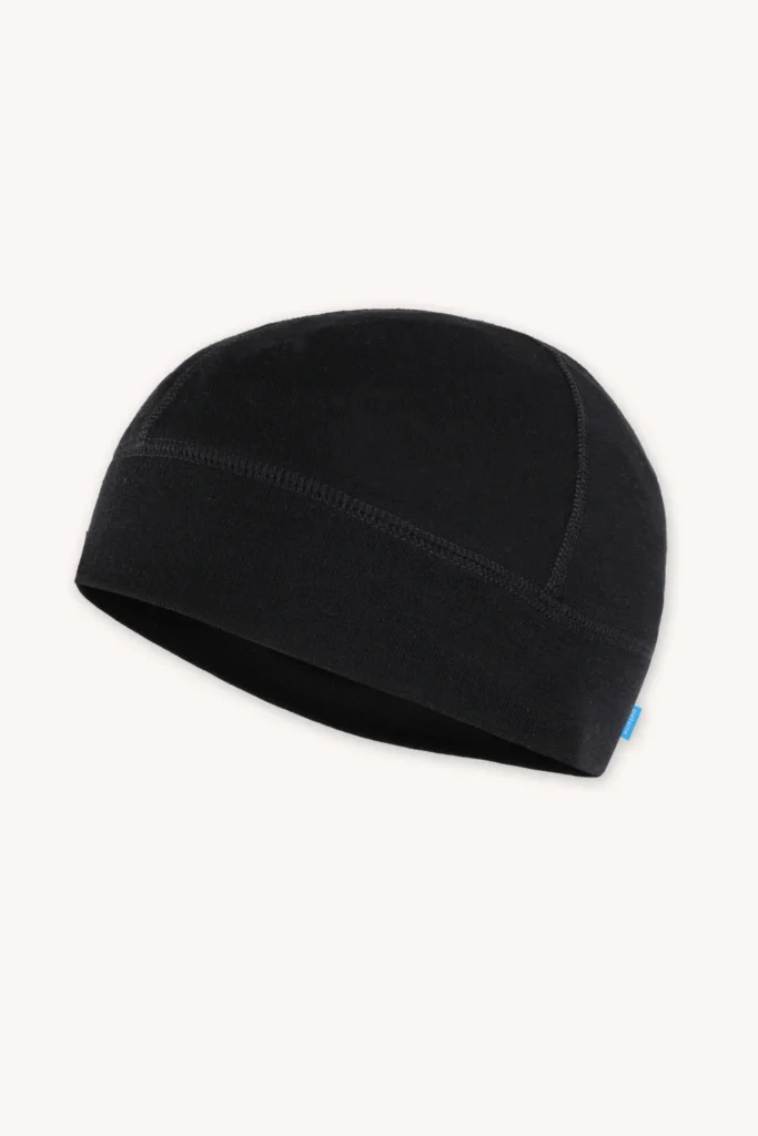 Jednoduchá černá čepice s jednoduchým prošíváním a malou modrou visačkou na boku, zobrazená na bílém pozadí.