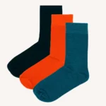 Tři páry ponožek jsou zobrazeny vedle sebe v černé, oranžové a tyalové barvě na bílém pozadí.