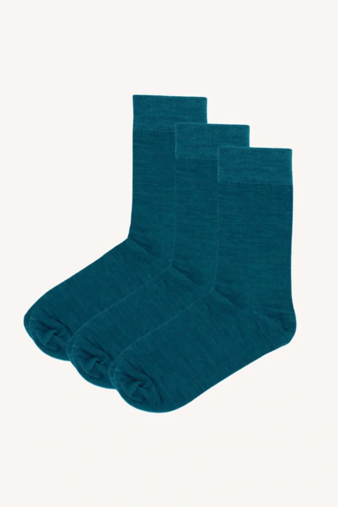 Tři páry ponožek v barvě teal jsou úhledně uspořádány v řadě na světlém pozadí.