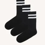 Tři páry černých ponožek se dvěma bílými pruhy u horního okraje, které jsou vedle sebe na hladkém světlém pozadí.
