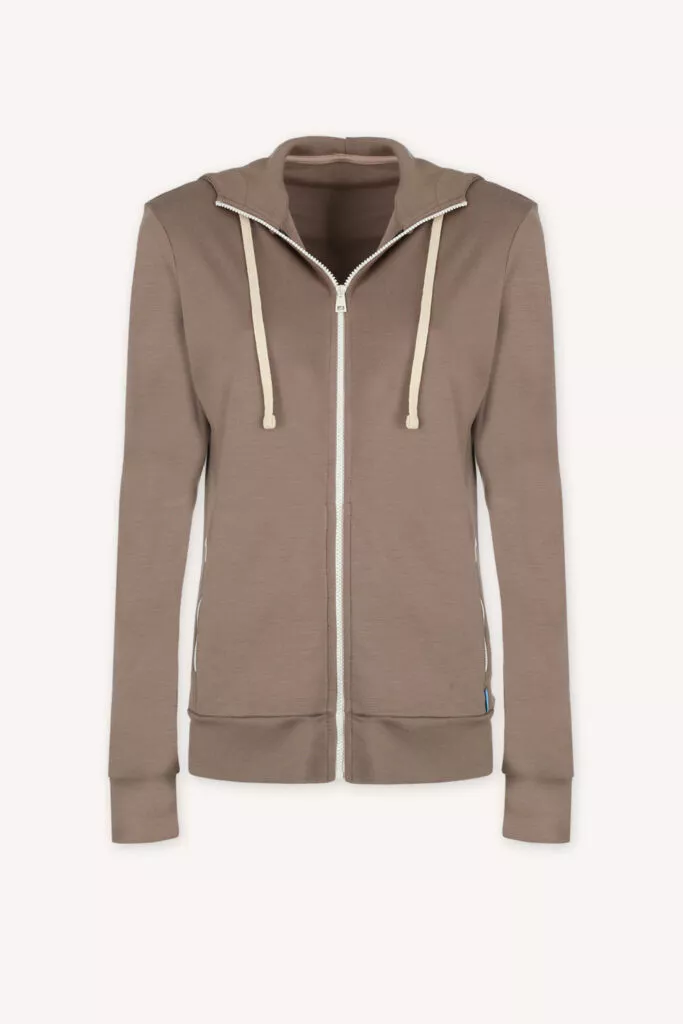 The Merino mikina na zip s kapucí dámská - mocha (250 g) je světle hnědá mikina na zip z welny merino 100 % s kapucí, krémovými šňůrkami, bočními kapsami a žebrovanými manžetami, zobrazená na světlém pozadí.